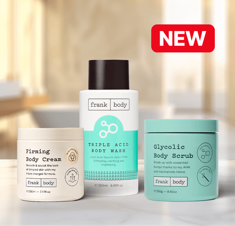 Three Frank Body skincare products: Firming Body Cream, Triple Acid Body Wash, and Glycolic Body Scrub with a "NEW" label in a bathroom setting.