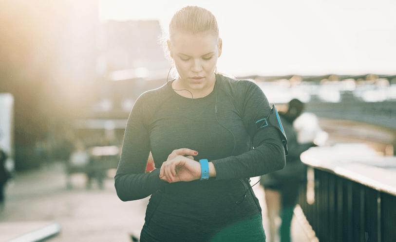 Woman outside exercising looking at fitness watch